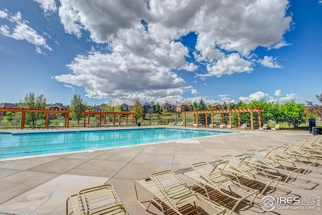 pool featuring fence, a pergola, and a patio