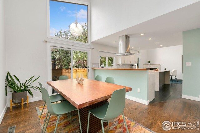 dining room with recessed lighting, baseboards, a towering ceiling, visible vents, and dark wood-type flooring