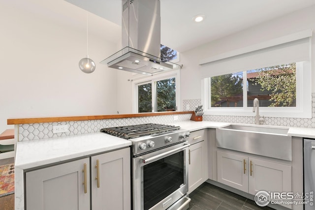 kitchen with backsplash, island range hood, stainless steel stove, a sink, and recessed lighting