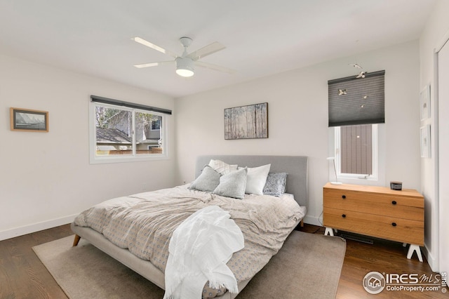 bedroom with a ceiling fan, baseboards, and wood finished floors