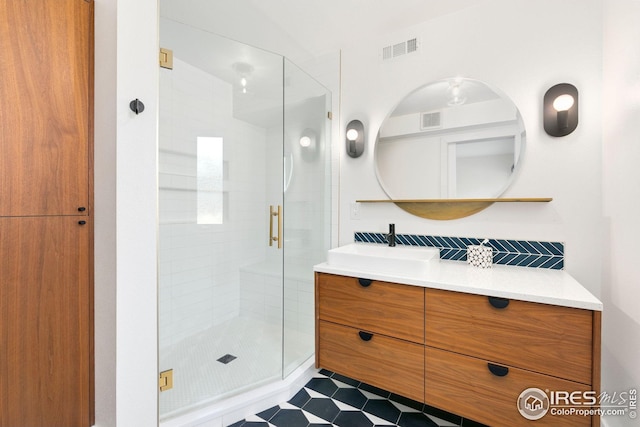 bathroom featuring vanity, visible vents, decorative backsplash, and a stall shower