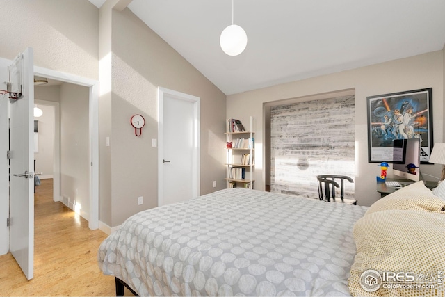 bedroom with light wood-style flooring and lofted ceiling