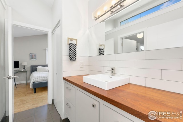 bathroom featuring vanity, decorative backsplash, and tile patterned floors
