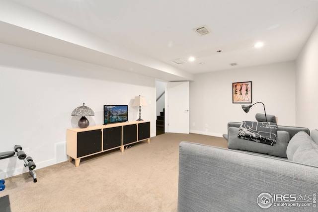 living area featuring stairs, baseboards, visible vents, and carpet
