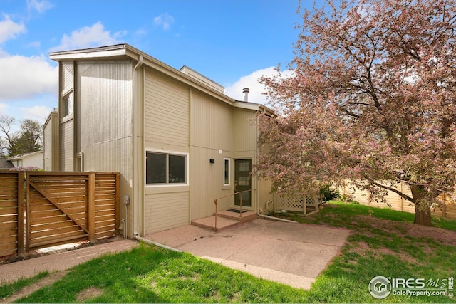 back of property with fence and a patio area