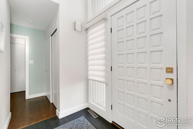 foyer featuring baseboards, dark wood-style flooring, and visible vents