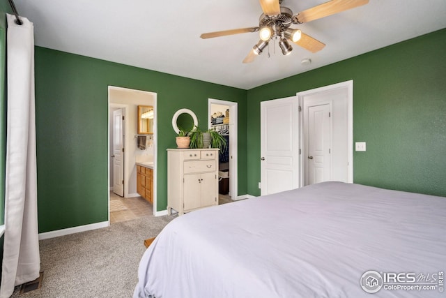 8596 Seattle Slew Ln, Wellington, CO 80549 - bedroom with ceiling fan, light colored carpet, baseboards, ensuite bathroom, and a spacious closet