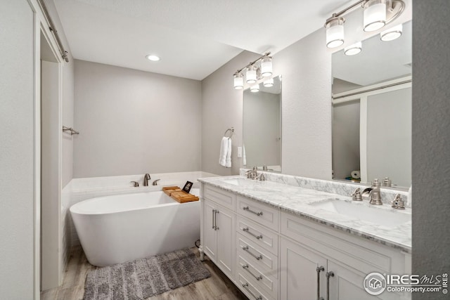 8596 Seattle Slew Ln, Wellington, CO 80549 - full bath featuring a sink, double vanity, wood finished floors, and a freestanding bath