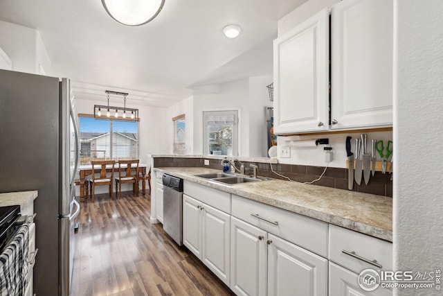 8596 Seattle Slew Ln, Wellington, CO 80549 - kitchen featuring dark wood-style floors, light countertops, white cabinets, a sink, and stainless steel appliances