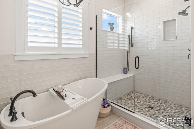 full bathroom featuring a shower stall and a soaking tub
