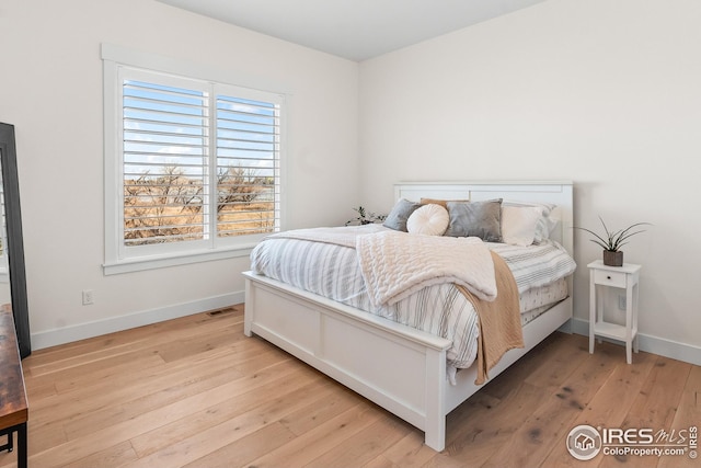 bedroom with baseboards and hardwood / wood-style floors