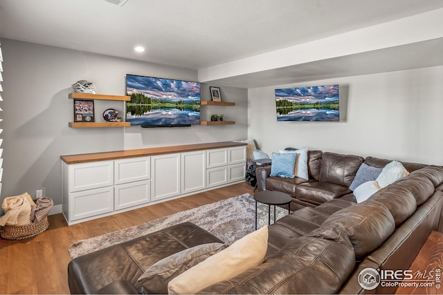 living area with recessed lighting, baseboards, and light wood finished floors