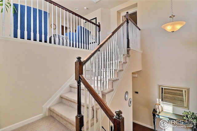 stairs with baseboards and carpet floors