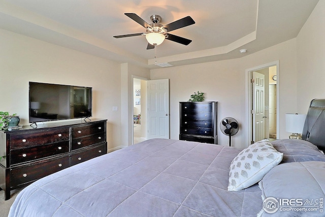 bedroom featuring a raised ceiling, a ceiling fan, and visible vents