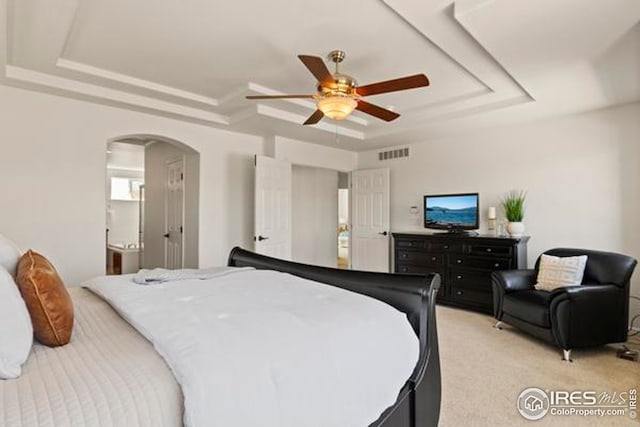 6117 Gold Dust Rd, Timnath, CO 80547 - bedroom featuring a raised ceiling, light colored carpet, arched walkways, and ceiling fan