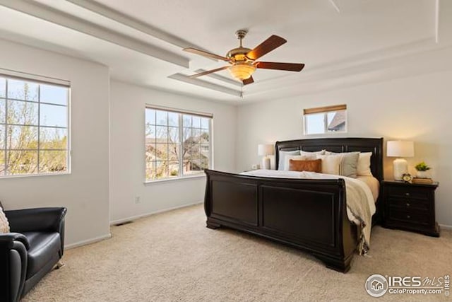 bedroom with baseboards, multiple windows, and light carpet