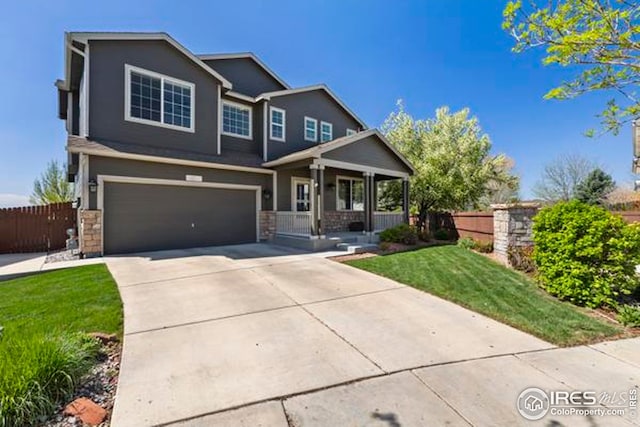 craftsman inspired home featuring fence, a front lawn, a garage, a porch, and concrete driveway