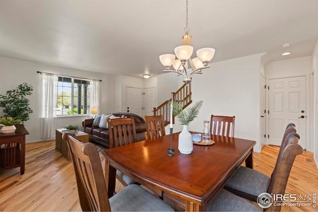 6117 Gold Dust Rd, Timnath, CO 80547 - dining area featuring light wood-style floors, a chandelier, and stairway