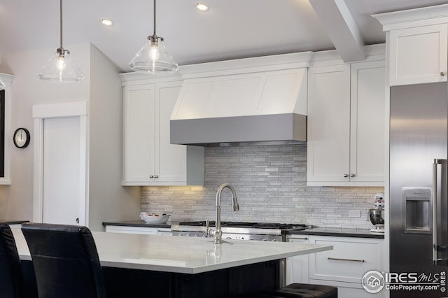 kitchen with high end fridge, white cabinetry, backsplash, and wall chimney range hood