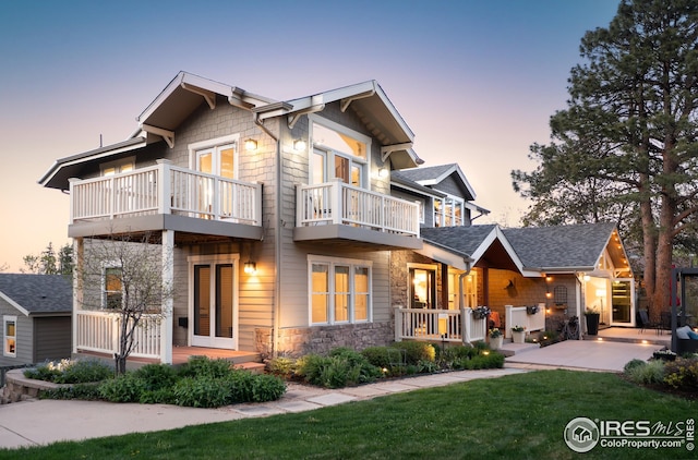 709 Baseline Rd, Boulder, CO 80302 - view of front facade featuring a balcony, stone siding, a porch, and a front lawn