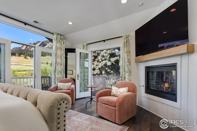bedroom featuring a glass covered fireplace, baseboards, recessed lighting, and wood finished floors