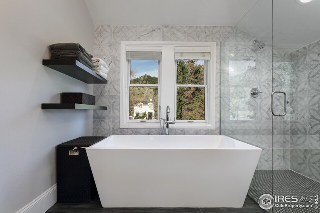709 Baseline Rd, Boulder, CO 80302 - bathroom with tile walls, a stall shower, a freestanding tub, and vaulted ceiling
