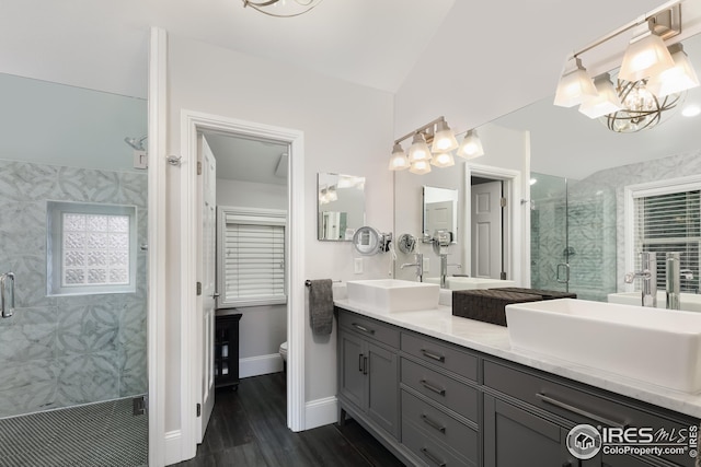 709 Baseline Rd, Boulder, CO 80302 - bathroom featuring a chandelier, a shower stall, wood finished floors, double vanity, and toilet