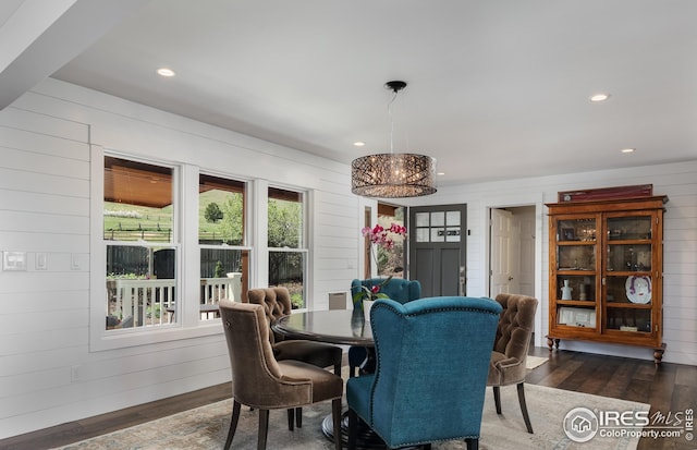 dining room with wood-type flooring, wood walls, and recessed lighting