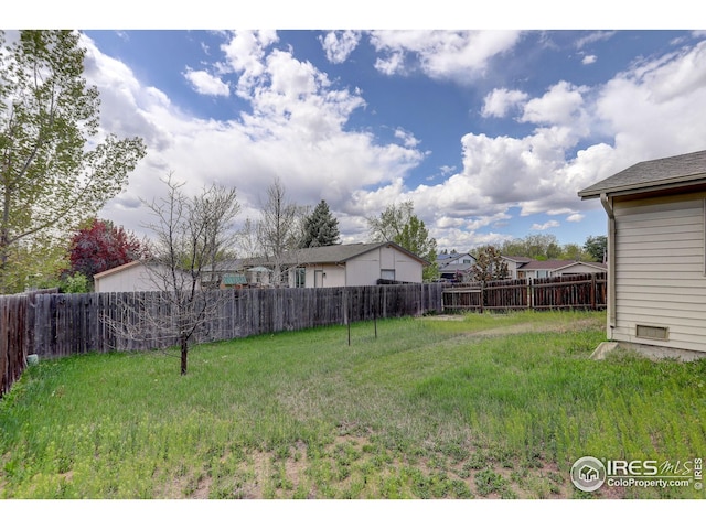 view of yard featuring a fenced backyard and a residential view