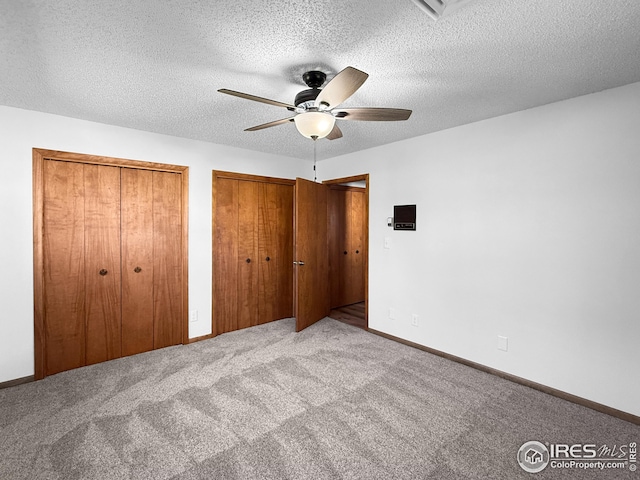 26237 County Road 65, Holyoke, CO 80734 - unfurnished bedroom with two closets, carpet flooring, ceiling fan, and a textured ceiling