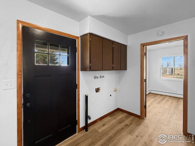 26237 County Road 65, Holyoke, CO 80734 - laundry room featuring a baseboard heating unit, cabinet space, light wood-style flooring, baseboards, and hookup for a washing machine