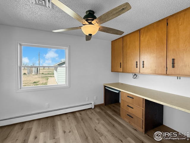 26237 County Road 65, Holyoke, CO 80734 - unfurnished office with a baseboard radiator, built in study area, a textured ceiling, light wood-style flooring, and a ceiling fan