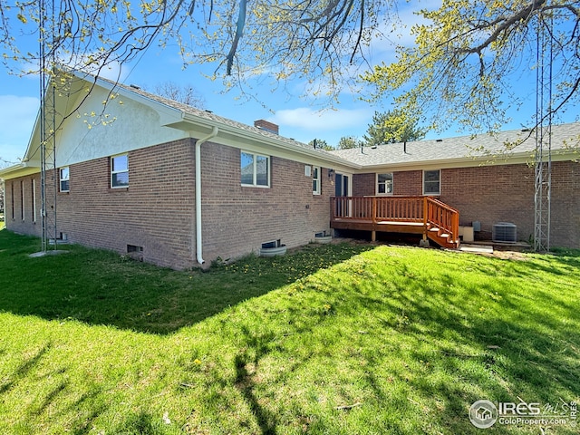 26237 County Road 65, Holyoke, CO 80734 - rear view of house featuring a wooden deck, a lawn, central AC, and brick siding