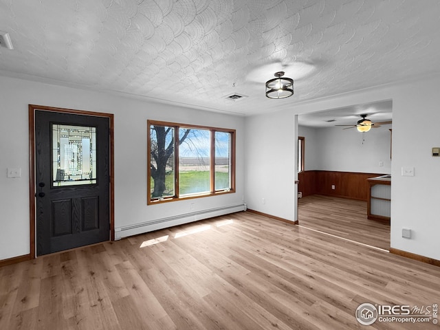 26237 County Road 65, Holyoke, CO 80734 - entrance foyer with a baseboard heating unit, light wood-style flooring, baseboards, a ceiling fan, and a wainscoted wall