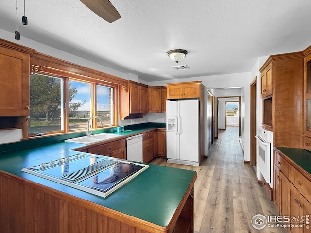 26237 County Road 65, Holyoke, CO 80734 - kitchen with white appliances, a sink, and brown cabinets