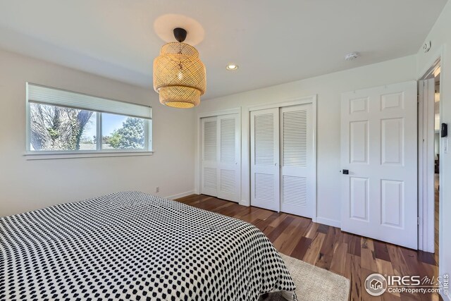 bedroom featuring baseboards, two closets, recessed lighting, and wood finished floors