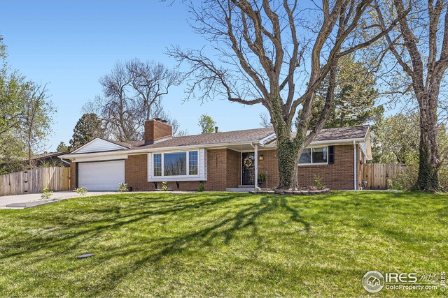 ranch-style home with brick siding, an attached garage, fence, and a front yard