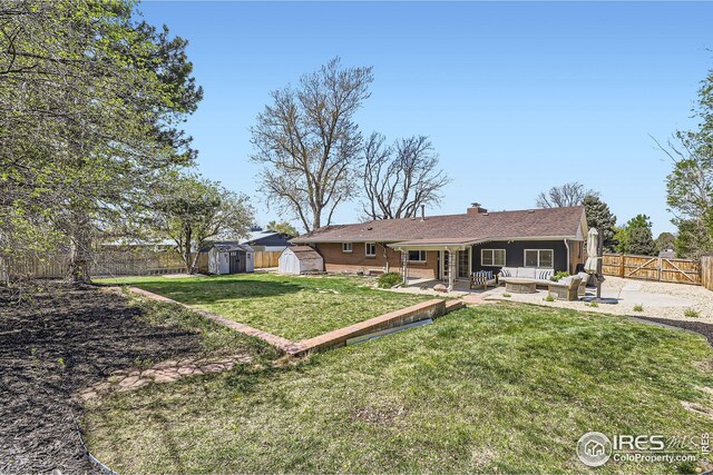rear view of house with an outdoor structure, a fenced backyard, an outdoor living space, a patio area, and a storage shed