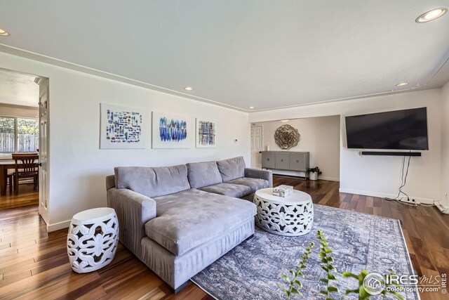 living area with recessed lighting, baseboards, and dark wood-style flooring