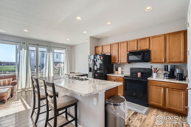 357 Chipman Dr, Windsor, CO 80550 - kitchen featuring light wood-style flooring, plenty of natural light, a sink, and black appliances
