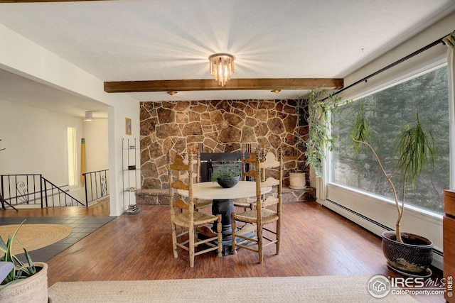 dining room with a baseboard radiator, wood finished floors, and beam ceiling