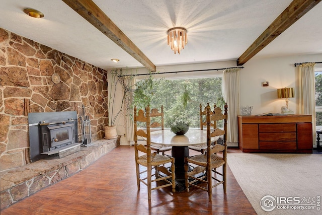 dining space with wood finished floors, a healthy amount of sunlight, and beamed ceiling