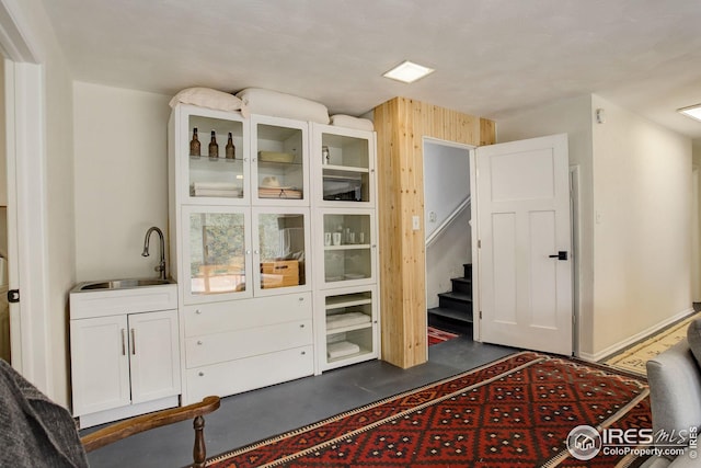 bedroom with a sink, concrete flooring, and wooden walls