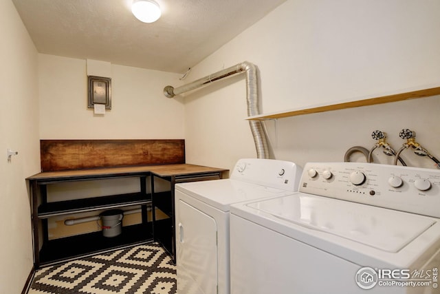 laundry area featuring separate washer and dryer, laundry area, and a textured ceiling