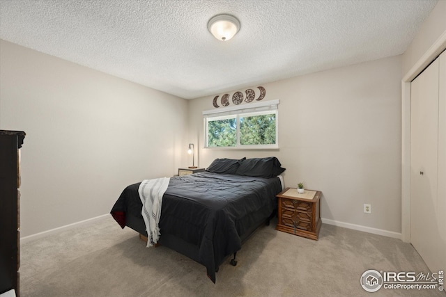 carpeted bedroom with baseboards and a textured ceiling