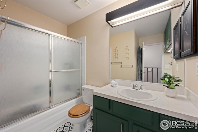 full bath featuring vanity, bath / shower combo with glass door, toilet, and visible vents
