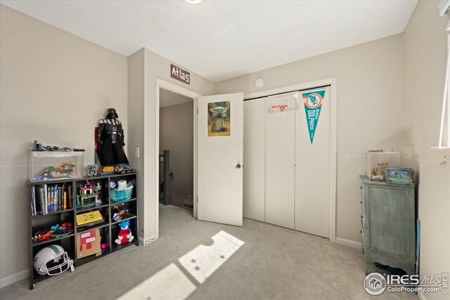 recreation room with carpet floors and baseboards