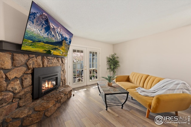 living area with french doors, wood finished floors, and a fireplace