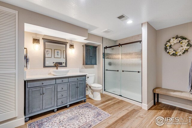 7628 Estate Cir, Niwot, CO 80503 - full bathroom featuring visible vents, a stall shower, wood finished floors, vanity, and toilet