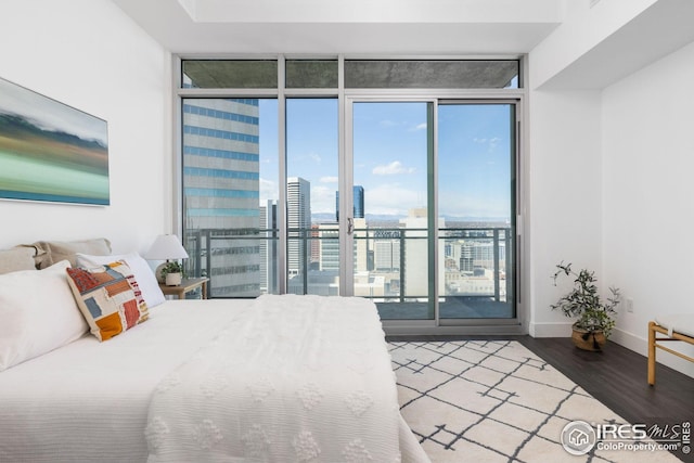 2001 Lincoln St Unit 2113, Denver, CO 80202 - bedroom with floor to ceiling windows, wood finished floors, access to outside, baseboards, and a view of city